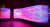 Bunte, leuchtende LED-Installation mit wellenförmigen Mustern in Pink, Lila und Blau.