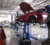 Autoreparaturwerkstatt mit mehreren auf Hebebühnen angehobenen Fahrzeugen.