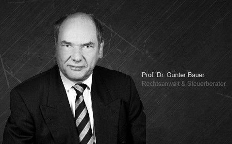 Porträt eines Mannes in Anzug mit dunklem Hintergrund, rechts mit Text.