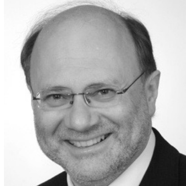 Porträt eines lächelnden Mannes mit Brille, Anzug und Krawatte, in Schwarz-Weiß.