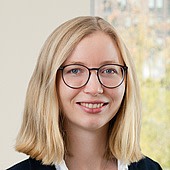 Junge Frau mit Brille und blonden Haaren, lächelnd