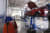 Autoreparaturwerkstatt mit mehreren auf Hebebühnen angehobenen Fahrzeugen.