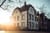Mehrfamilienhaus bei Sonnenuntergang mit Bäumen im Vordergrund.