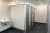 Damen-Waschräume mit weißen und grauen Toilettenkabinen und einem weißen Waschbecken.